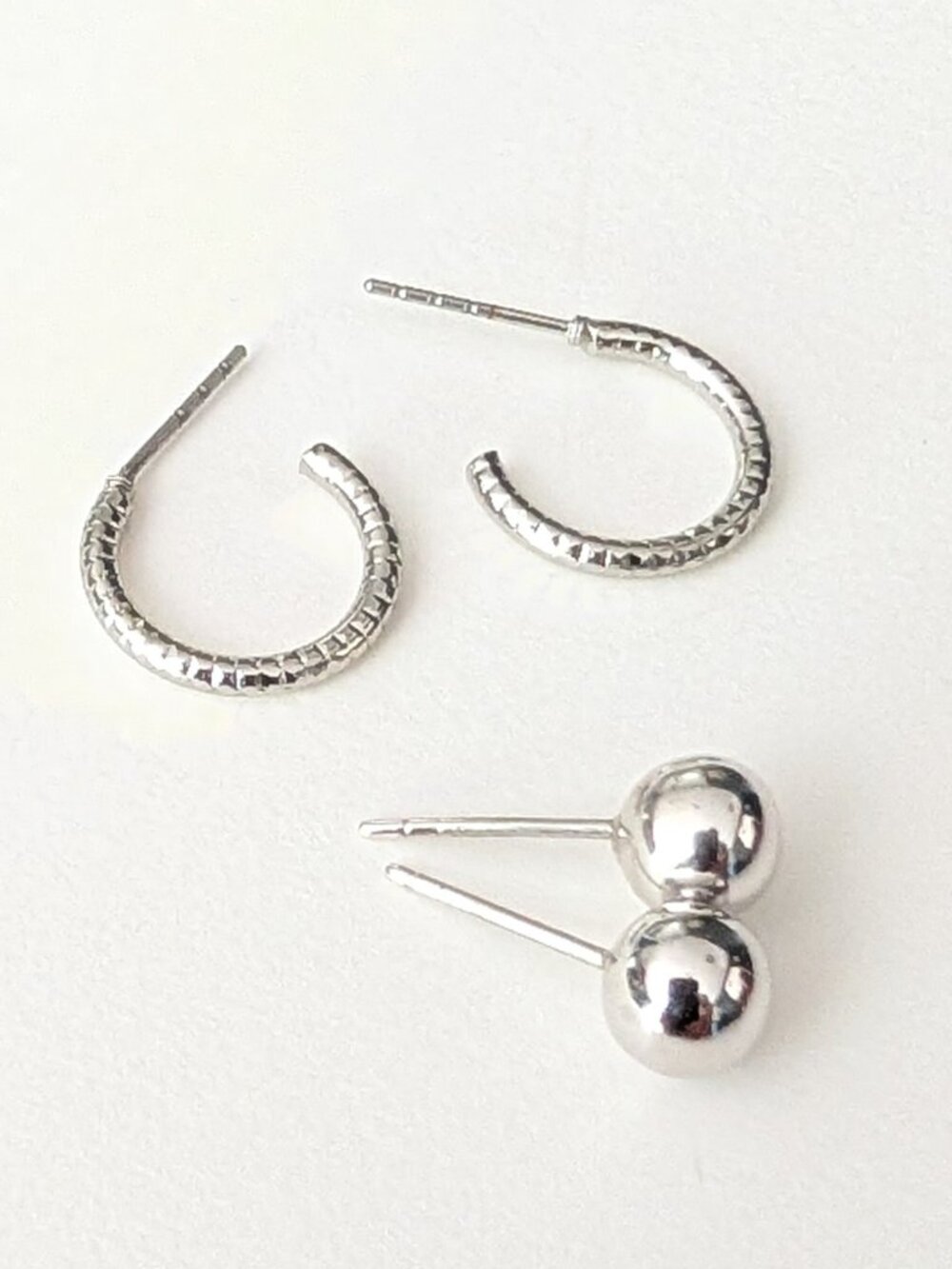 2 pairs of silver tone earrings- round ball studs and small textured hoops